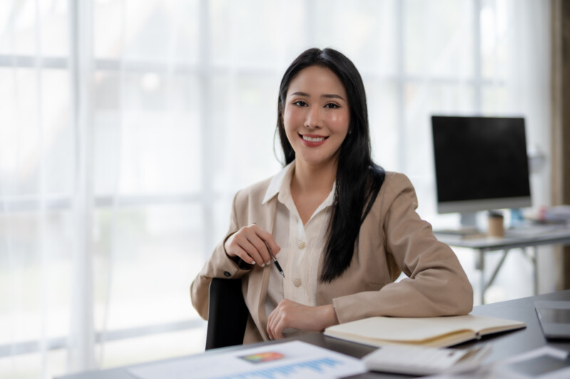 Charming Asian business woman have a happy of working laptop at Charming Asian business woman have a happy of working laptop at the office. Looking at camera.